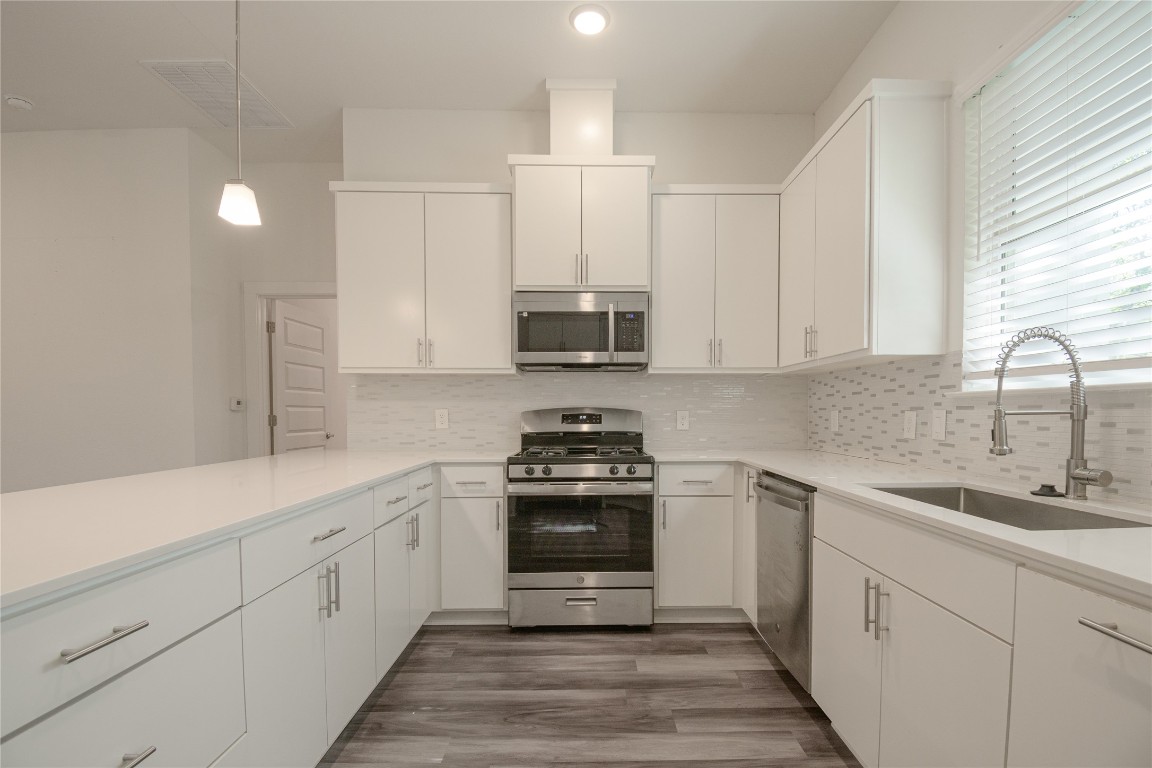 6325 Ponca Street, Unit A Austin, TX 78741 - Photo 8 of 21 a kitchen with stainless steel appliances granite countertop a sink stove and refrigerator