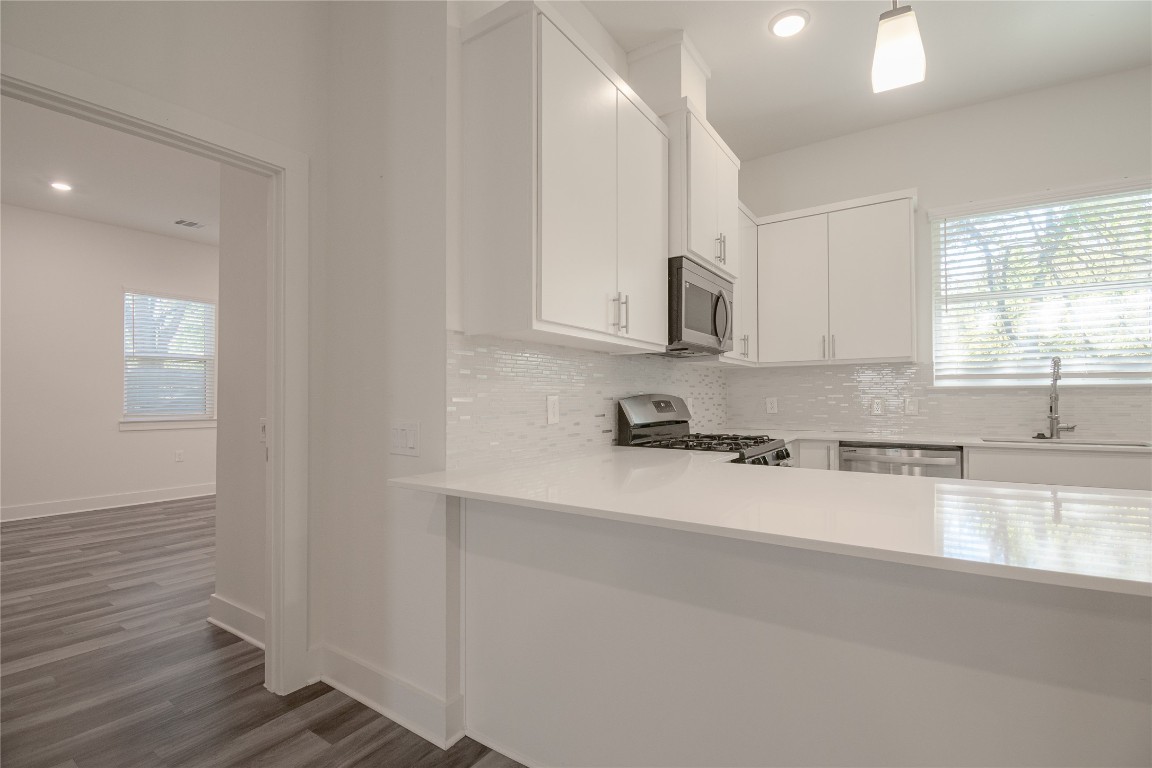 6325 Ponca Street, Unit A Austin, TX 78741 - Photo 9 of 21 a large white kitchen with wooden floors and white cabinets