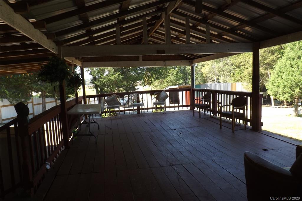 7080 Woodleaf Road Woodleaf, NC 27054 - Photo 7 of 21 a porch with wooden floor outdoor seating and yard in the back