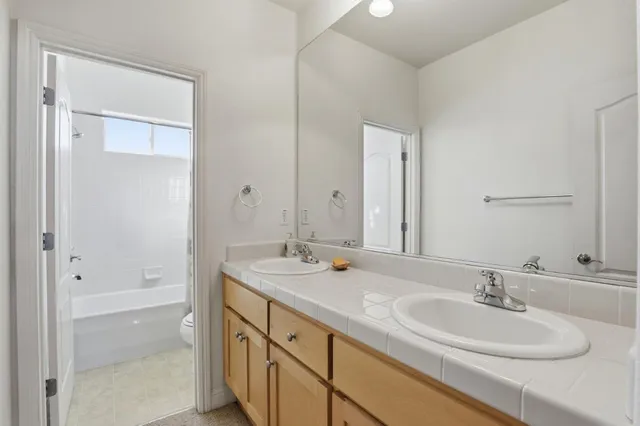 a bathroom with a sink double vanity granite tub and shower