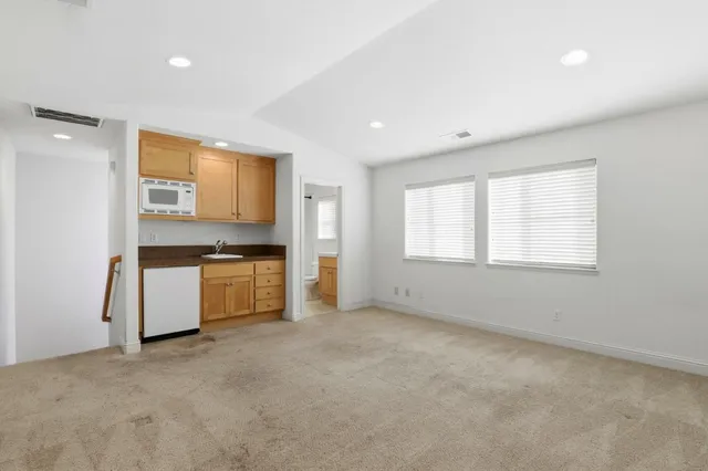 a view of kitchen with refrigerator and window