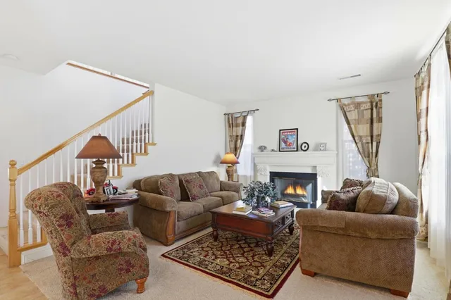 a living room with furniture a fireplace and a large window
