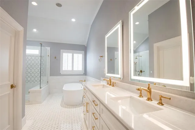 a spacious bathroom with a double vanity sink toilet mirror and bathtub