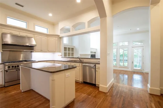a kitchen with stainless steel appliances granite countertop a stove a sink and a refrigerator