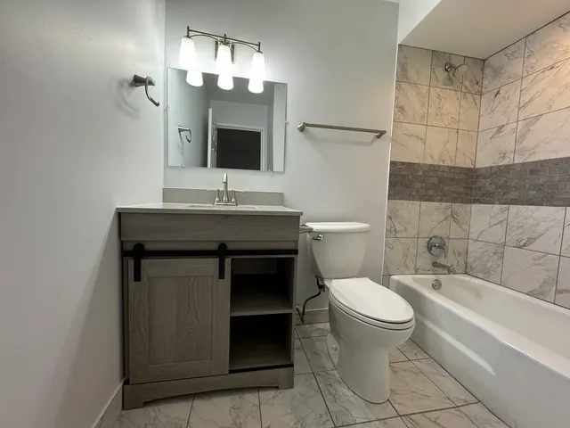 a bathroom with a toilet sink and mirror