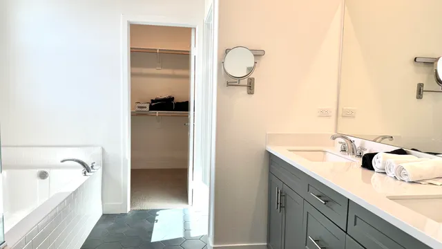 a bathroom with a tub sink and mirror