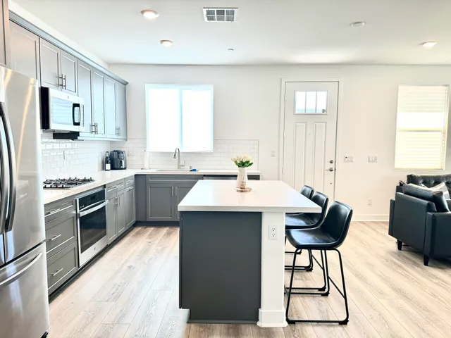 a kitchen with a table chairs microwave and cabinets