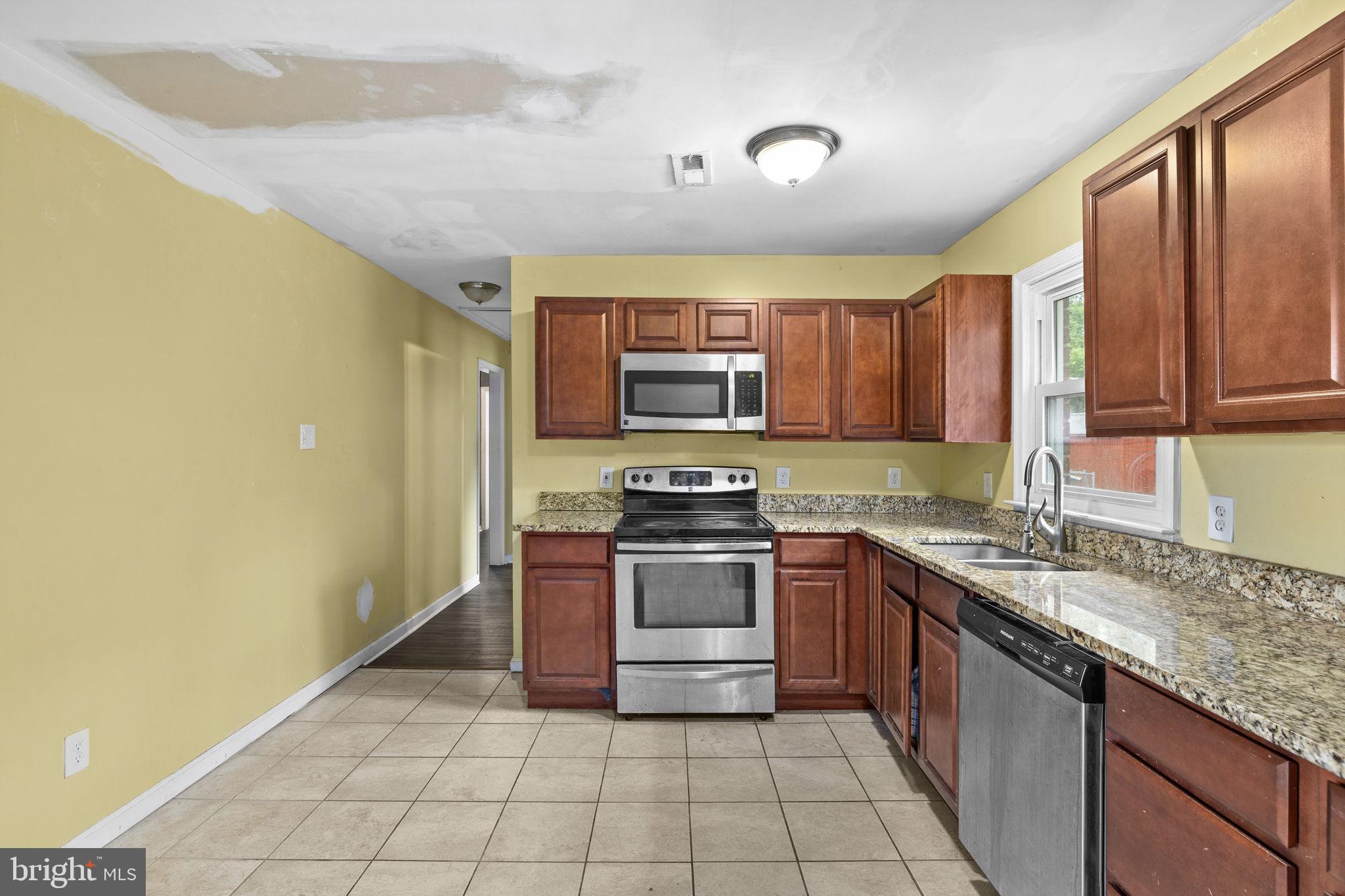 13245 Glen Level Drive Ruther Glen, VA 22546 - Photo 11 of 37 a kitchen with stainless steel appliances granite countertop a stove a sink and a microwave