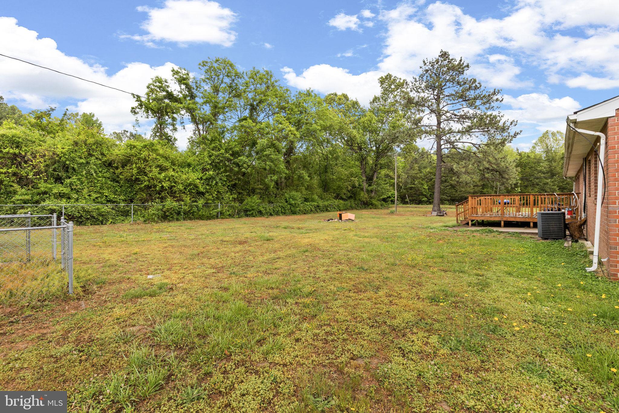 13245 Glen Level Drive Ruther Glen, VA 22546 - Photo 32 of 37 a view of a green field with trees in the background