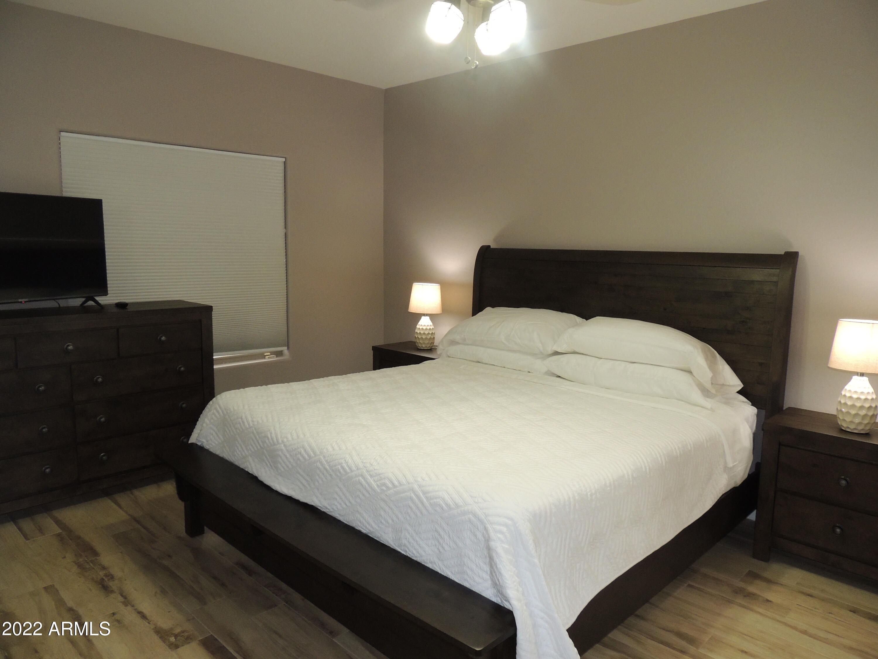 525 North Miller Road, Unit 129 Scottsdale, AZ 85257 - Photo 11 of 19 a bedroom with a bed and a flat tv screen on a dresser