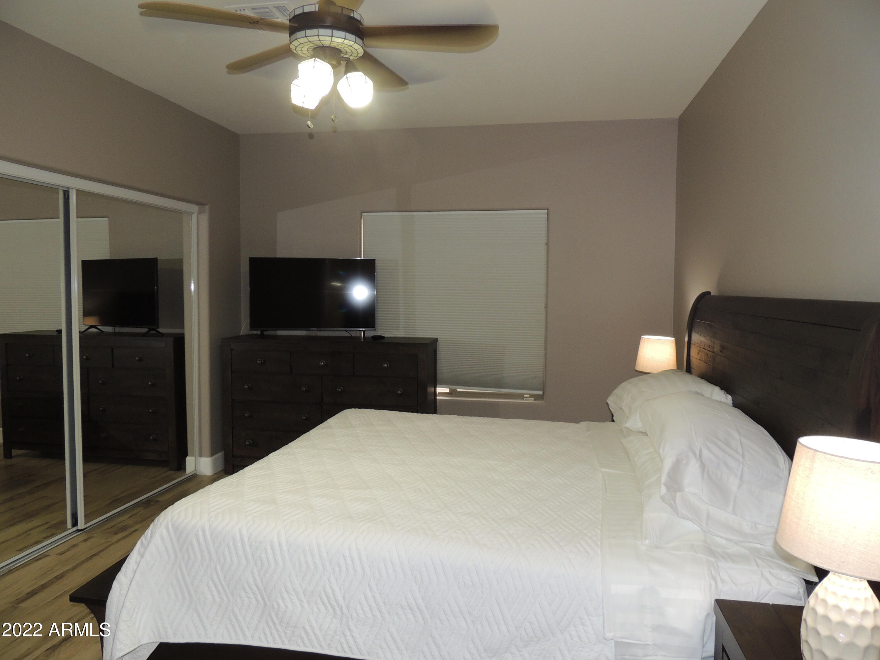 525 North Miller Road, Unit 129 Scottsdale, AZ 85257 - Photo 12 of 19 a bedroom with a bed and a lamp on dresser
