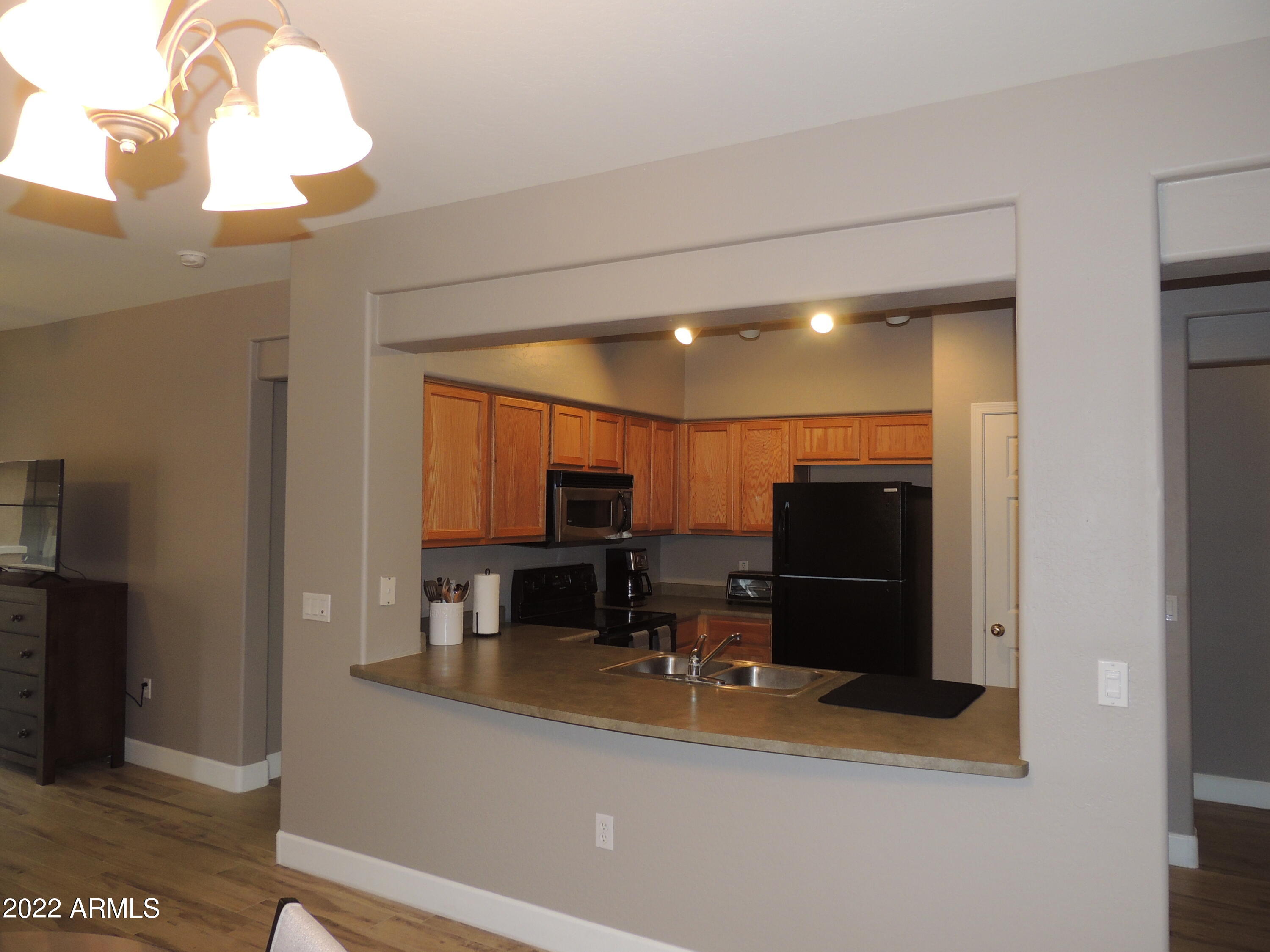 525 North Miller Road, Unit 129 Scottsdale, AZ 85257 - Photo 4 of 19 a view of kitchen with stainless steel appliances kitchen island microwave and refrigerator