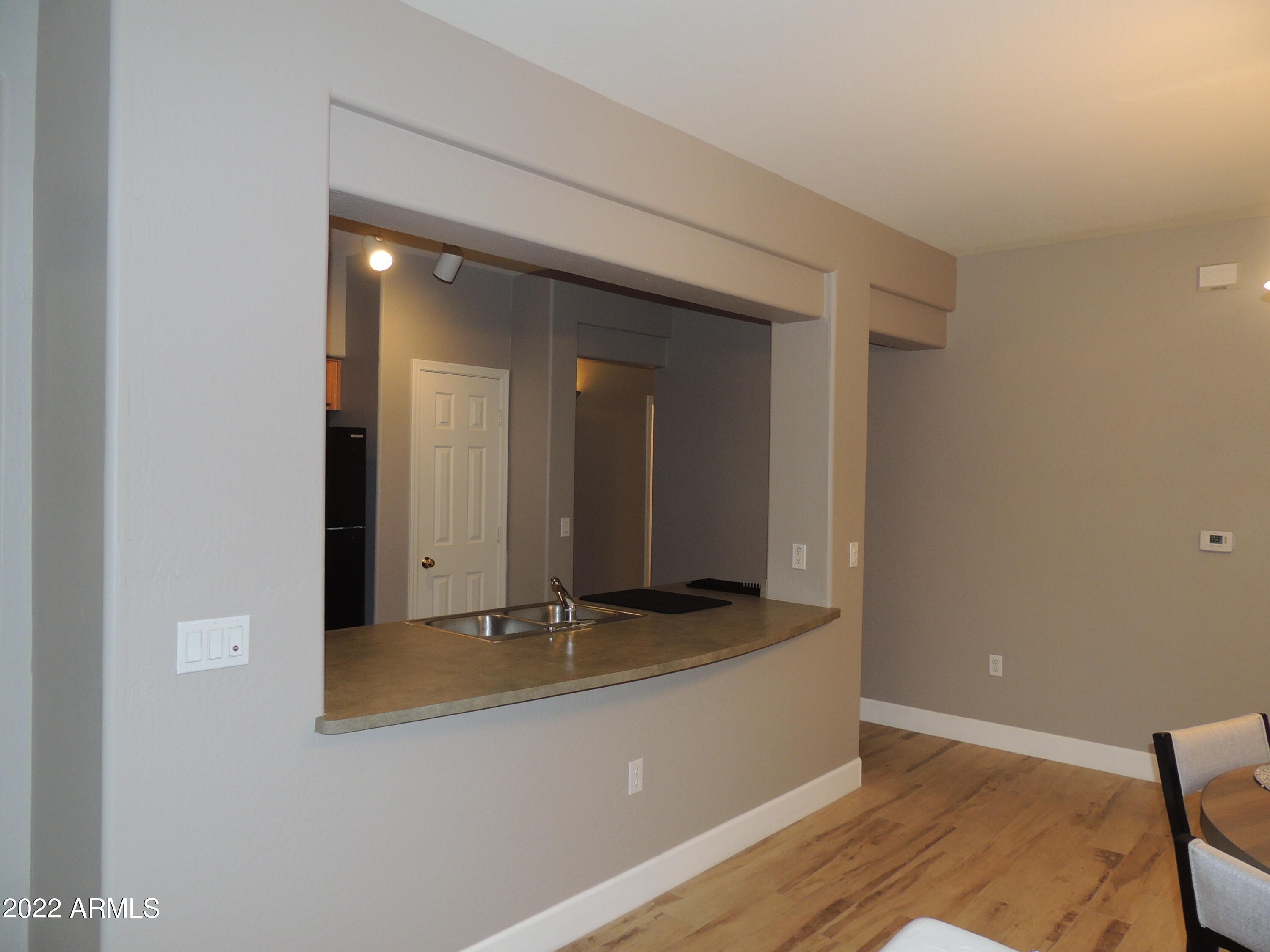 525 North Miller Road, Unit 129 Scottsdale, AZ 85257 - Photo 7 of 19 a hallway with a large mirror and vanity
