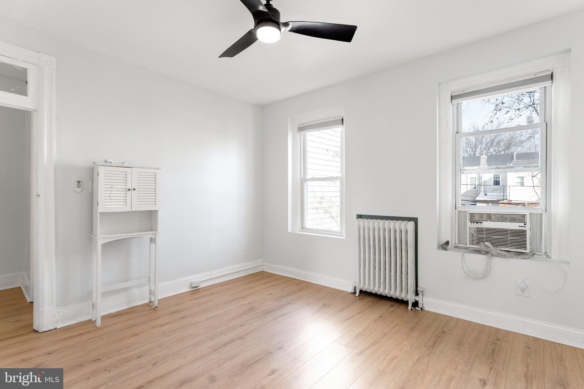 621 Kenyon Street Northwest Washington, DC 20010 - Photo 14 of 25 an empty room with wooden floor cabinet and windows