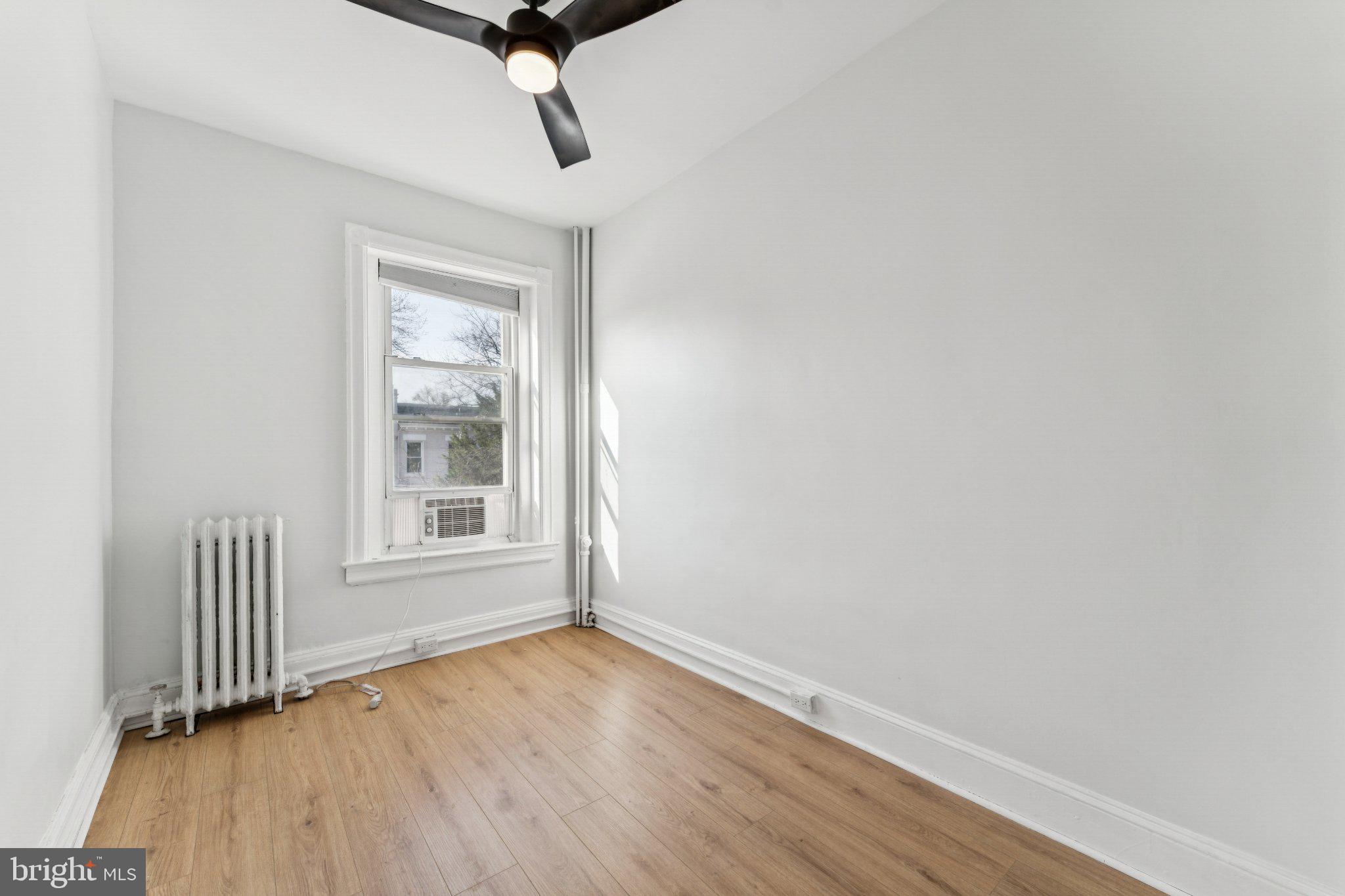 621 Kenyon Street Northwest Washington, DC 20010 - Photo 16 of 25 a view of an empty room with wooden floor and a window