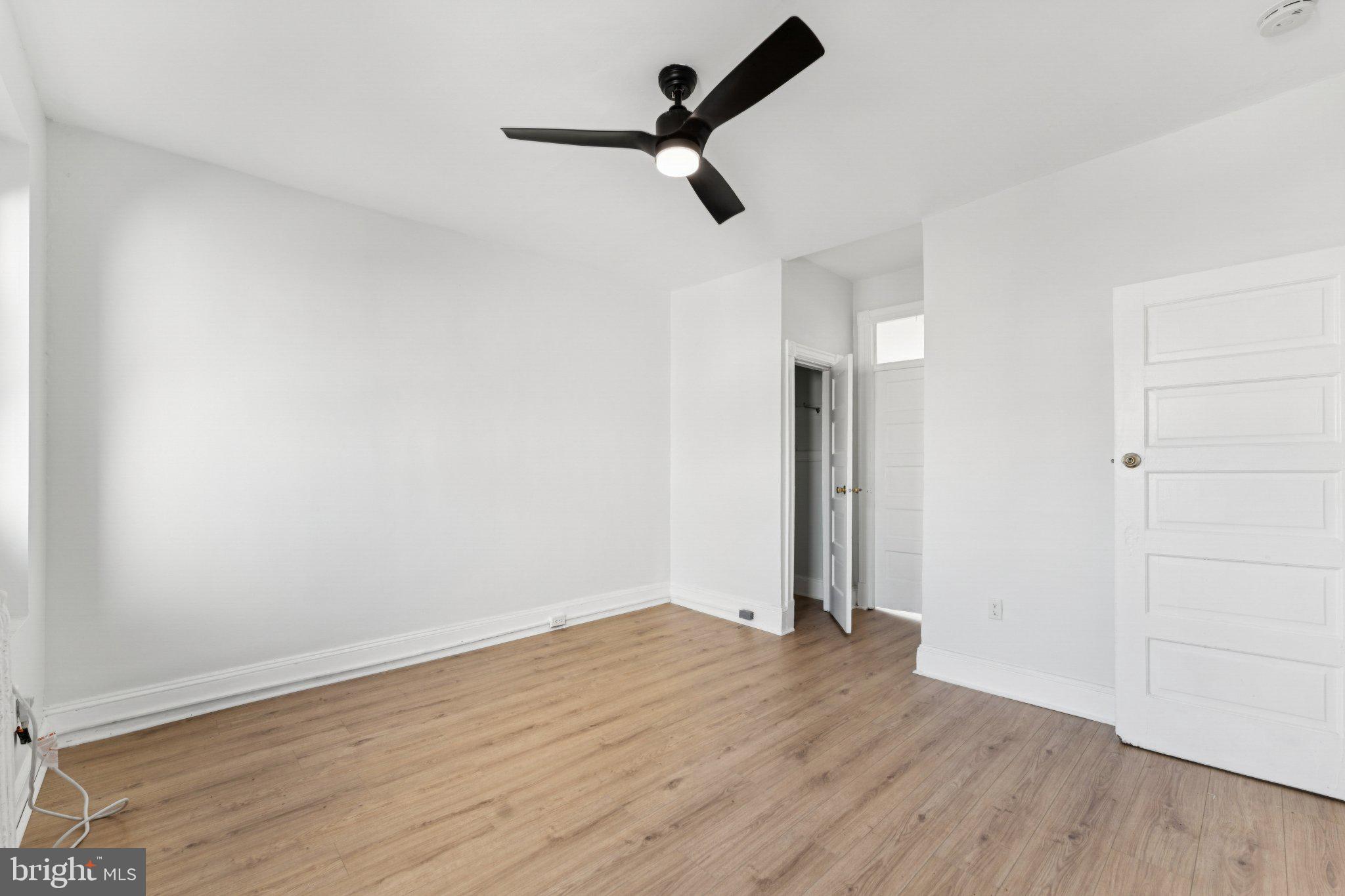 621 Kenyon Street Northwest Washington, DC 20010 - Photo 19 of 25 an empty room with wooden floor ceiling fan and window