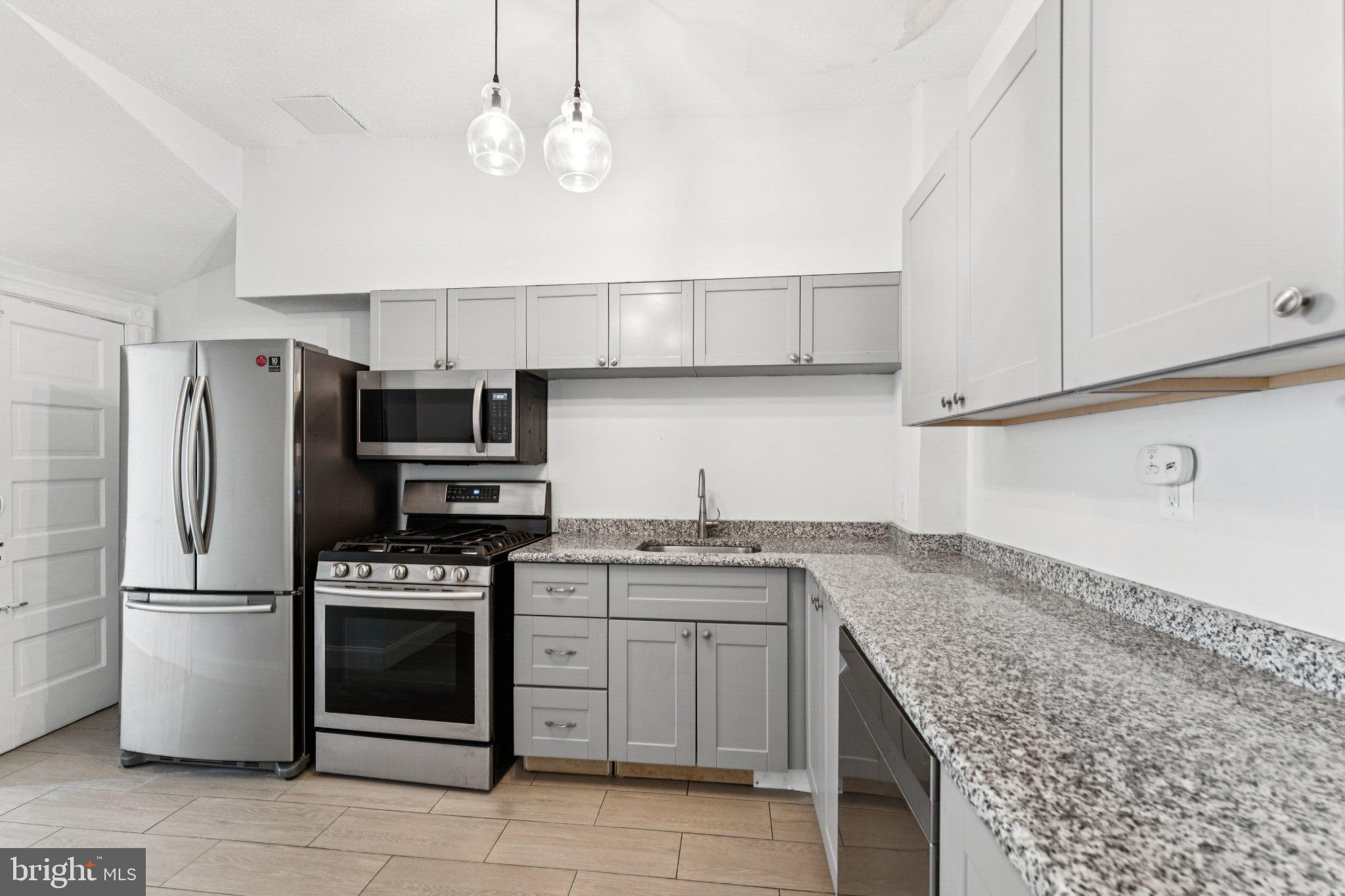 621 Kenyon Street Northwest Washington, DC 20010 - Photo 9 of 25 a kitchen with stainless steel appliances granite countertop a sink stove and refrigerator