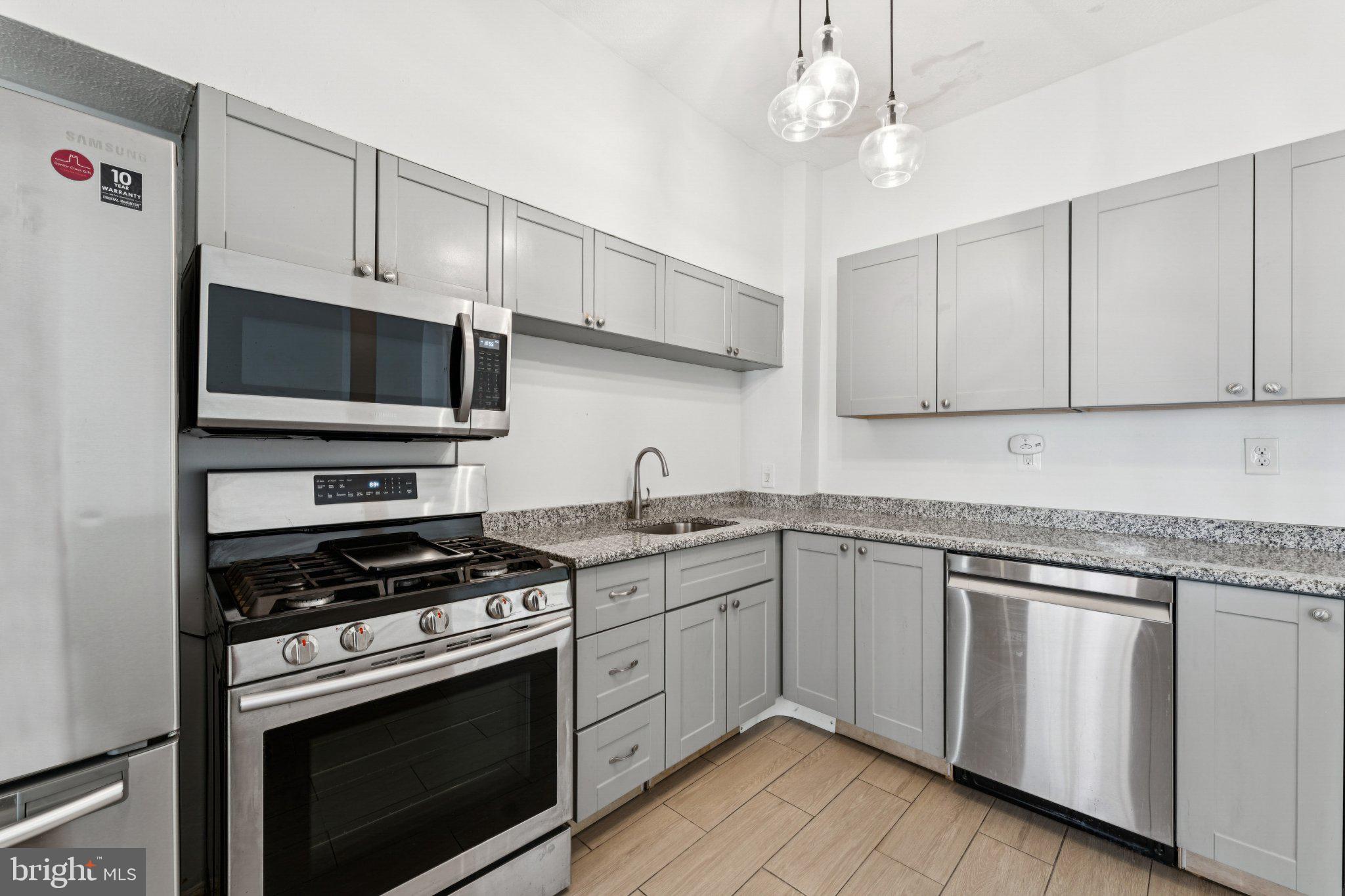621 Kenyon Street Northwest Washington, DC 20010 - Photo 10 of 25 a kitchen with cabinets stainless steel appliances and a sink
