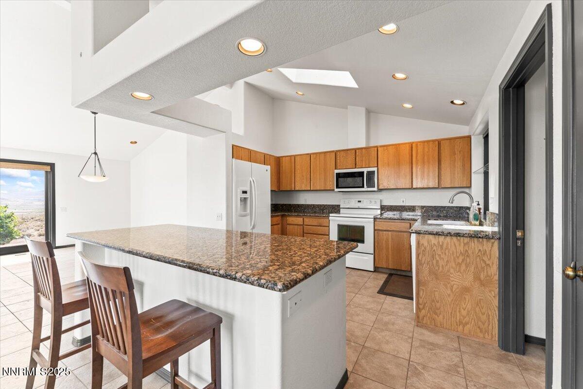 5455 Wild Horse Road Reno, NV 89510 - Photo 11 of 33 a kitchen with stainless steel appliances granite countertop a stove top oven a sink island and chairs