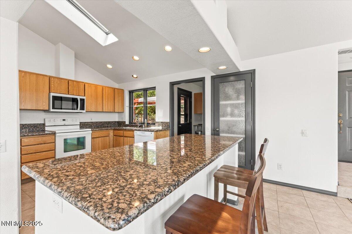 5455 Wild Horse Road Reno, NV 89510 - Photo 12 of 33 a kitchen with stainless steel appliances granite countertop a stove top oven a sink a dining table and chairs