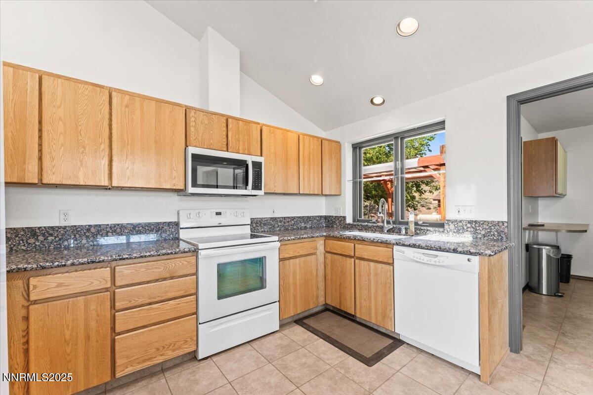 5455 Wild Horse Road Reno, NV 89510 - Photo 13 of 33 a kitchen with kitchen island granite countertop stainless steel appliances a stove sink and microwave