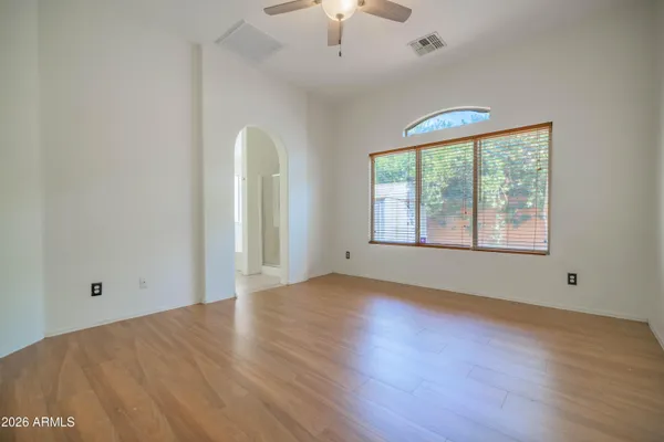a view of an empty room with a chandelier fan