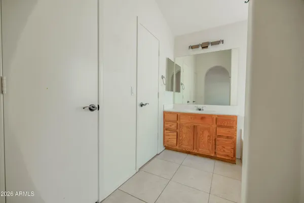 a spacious bathroom with a double vanity sink a mirror and a toilet
