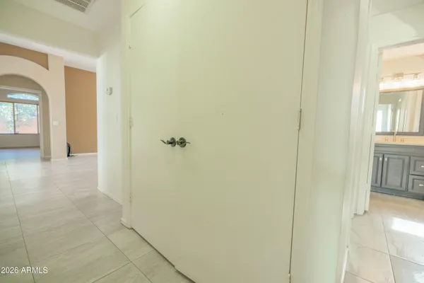 an empty room with closet and a chandelier fan