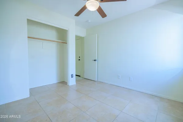 an empty room with closet and chandelier fan