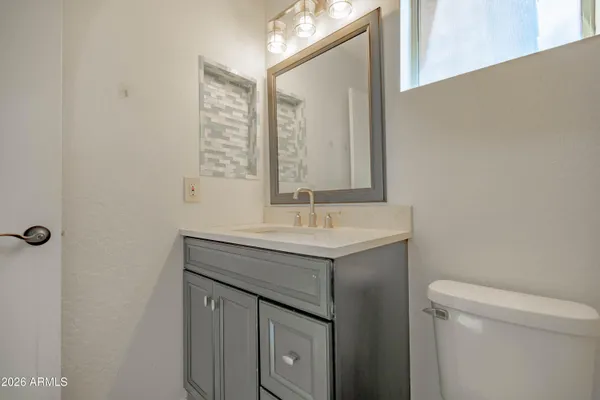 an empty room with wooden floor ceiling fan and windows