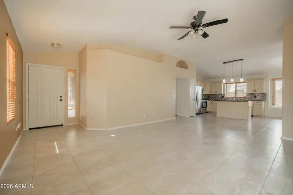 a view of a livingroom with a kitchen stove and a ceiling fan