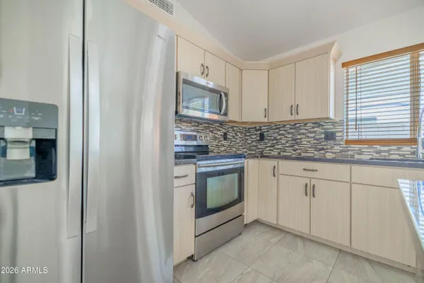 a kitchen with stainless steel appliances granite countertop white cabinets and window