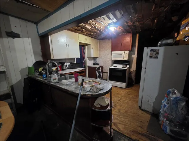 a kitchen with stainless steel appliances kitchen island granite countertop a sink dishwasher stove and refrigerator with wooden floor