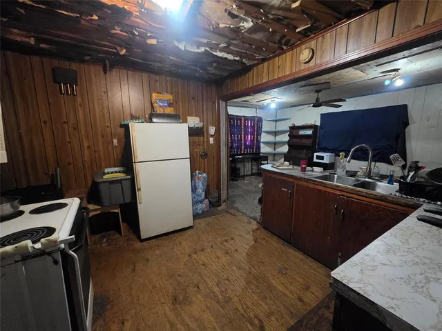a kitchen with refrigerator and chairs