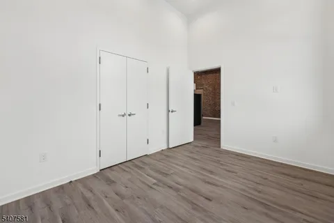 an empty room with wooden floor and closet
