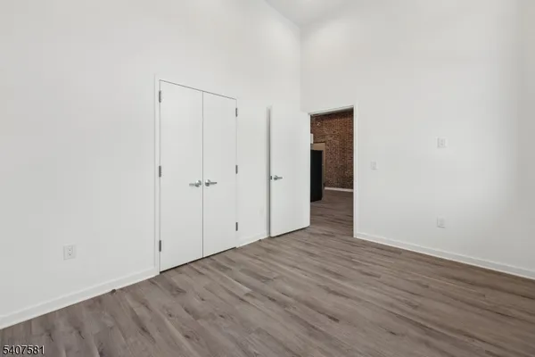 an empty room with wooden floor and closet