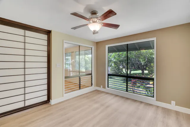 an empty room with wooden floor and windows