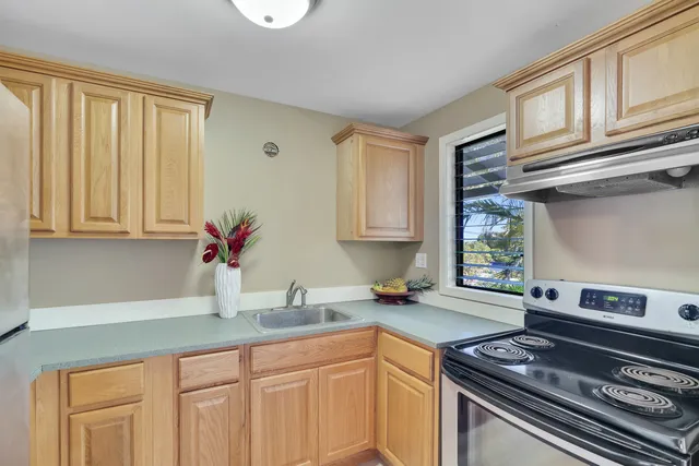 a kitchen with stainless steel appliances granite countertop a sink stove and cabinets