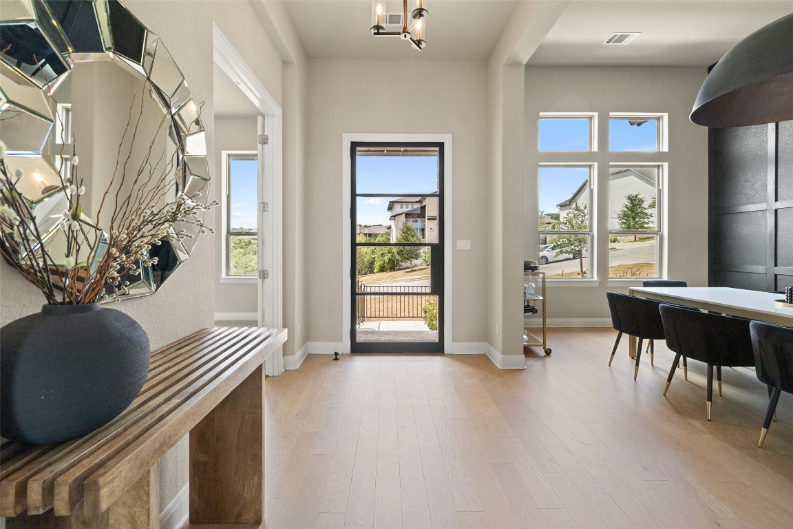 2220 Normandy View Leander, TX 78641 - Photo 11 of 40 Doorway featuring wood finished floors, healthy amount of natural light, and a chandelier