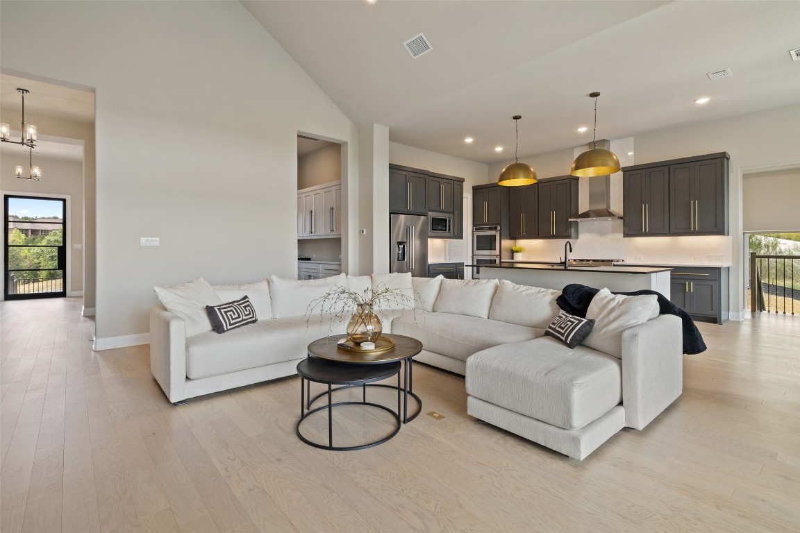 2220 Normandy View Leander, TX 78641 - Photo 17 of 40 Living room with light wood-type flooring, high vaulted ceiling, a chandelier, and recessed lighting