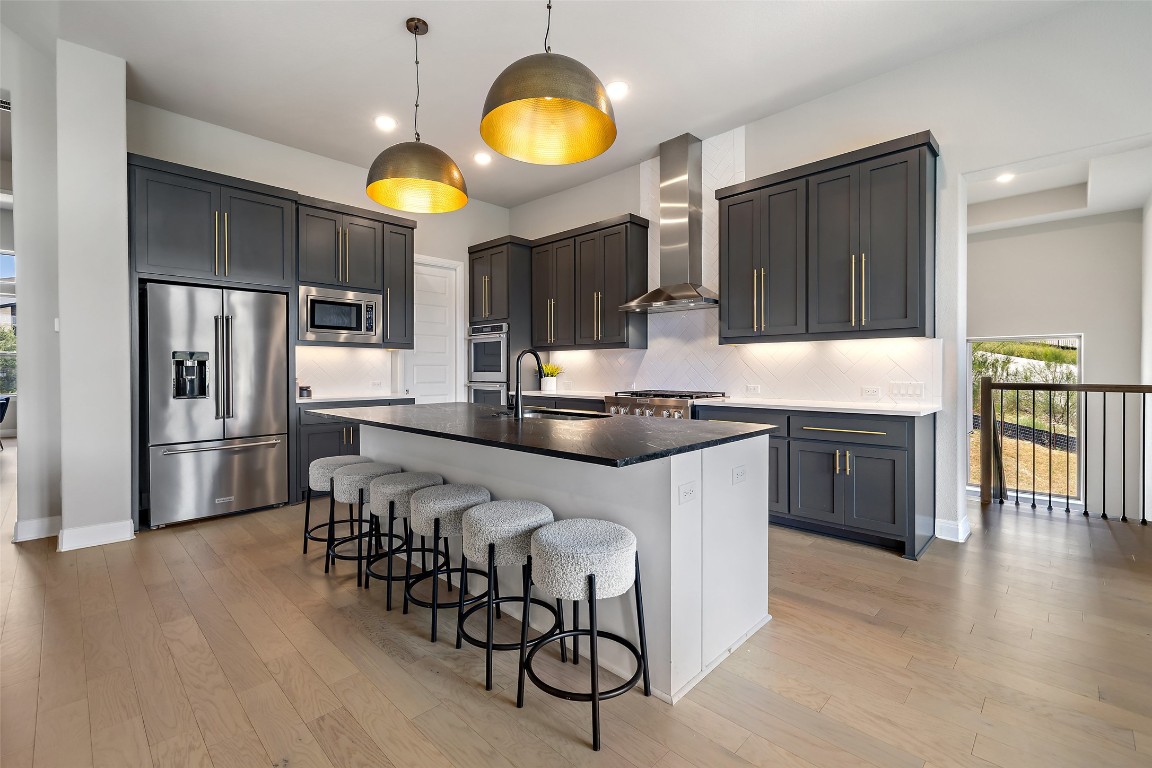 2220 Normandy View Leander, TX 78641 - Photo 18 of 40 Kitchen with healthy amount of natural light, a breakfast bar area, stainless steel appliances, pendant lighting, and recessed lighting