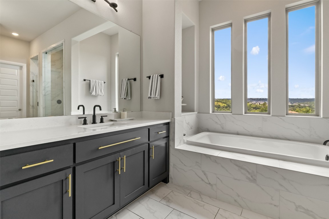2220 Normandy View Leander, TX 78641 - Photo 25 of 40 Bathroom with vanity, a bath, a marble finish shower, and light marble finish flooring