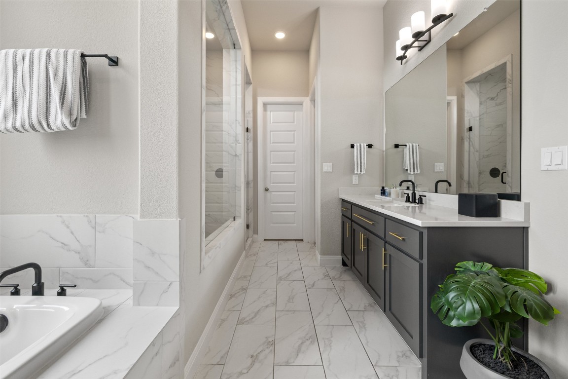 2220 Normandy View Leander, TX 78641 - Photo 26 of 40 Full bath featuring a garden tub, double vanity, a marble finish shower, and light marble finish floors