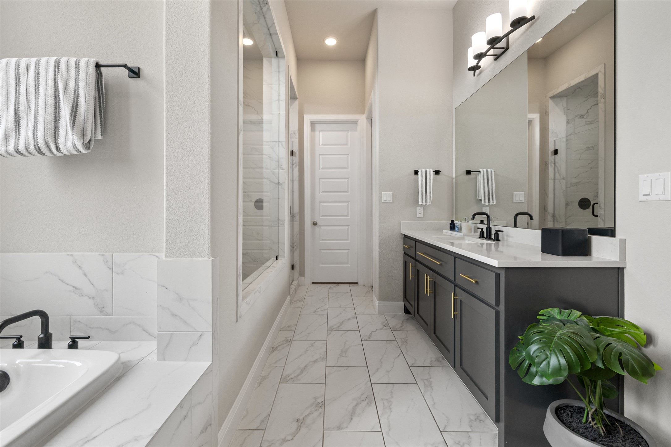 2220 Normandy View Leander, TX 78641 - Photo 26 of 40 a spacious bathroom with a double vanity sink a mirror a bathtub and shower
