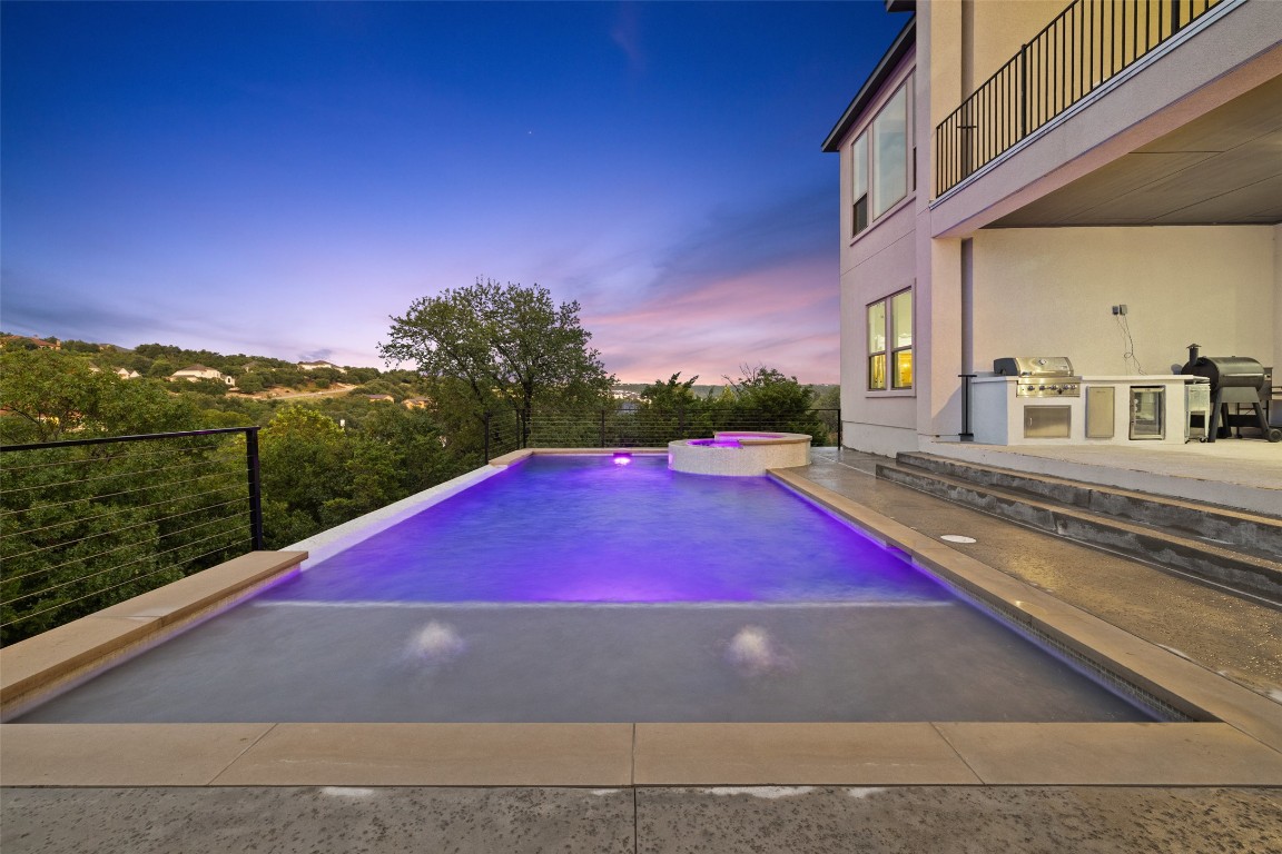 2220 Normandy View Leander, TX 78641 - Photo 3 of 40 View of swimming pool featuring exterior kitchen, a pool with connected hot tub, a patio area, and a balcony