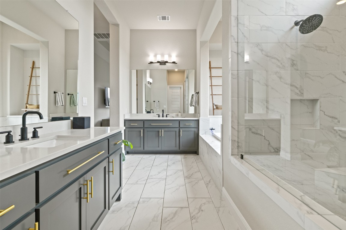 2220 Normandy View Leander, TX 78641 - Photo 30 of 40 Full bath with a garden tub, two vanities, a marble finish shower, and light marble finish floors