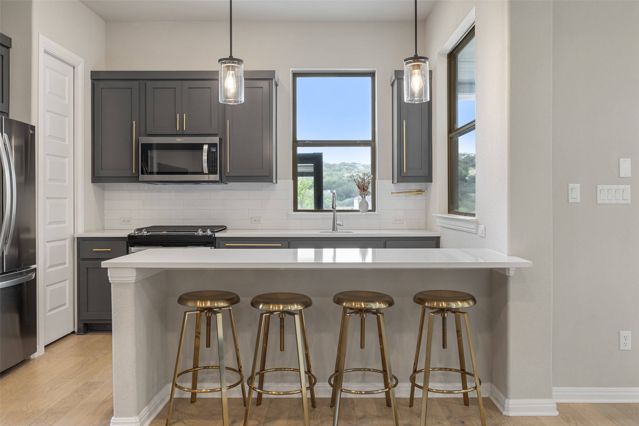 2220 Normandy View Leander, TX 78641 - Photo 34 of 40 a kitchen with stainless steel appliances kitchen island a table chairs in it and a microwave