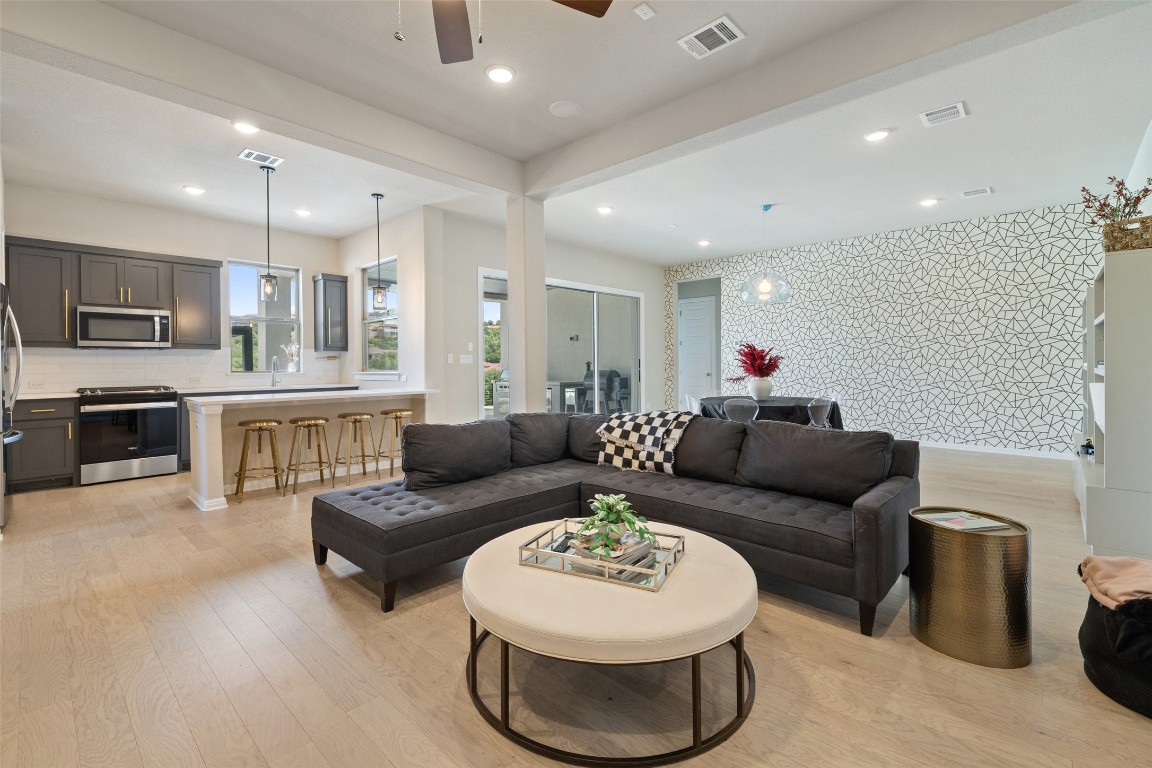 2220 Normandy View Leander, TX 78641 - Photo 35 of 40 Living area featuring wallpapered walls, light wood-style floors, recessed lighting, an accent wall, and a ceiling fan