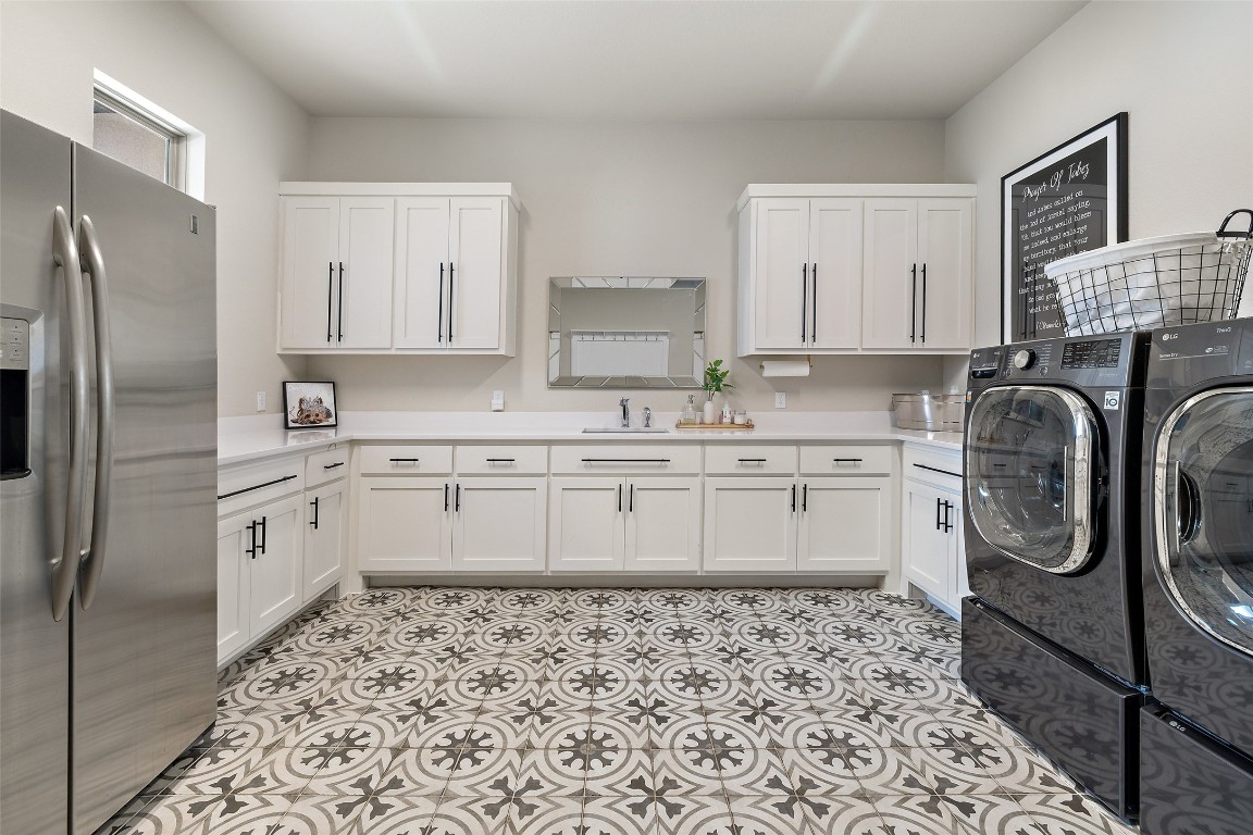2220 Normandy View Leander, TX 78641 - Photo 38 of 40 Laundry room with independent washer and dryer, cabinet space, and light tile patterned floors