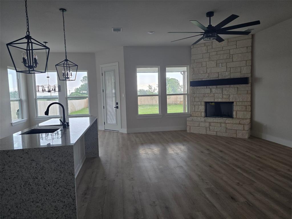 808 N Avenue East Springtown, TX 76082 - Photo 6 of 21 a view of a kitchen with a stove wooden floor a kitchen view and a chandelier